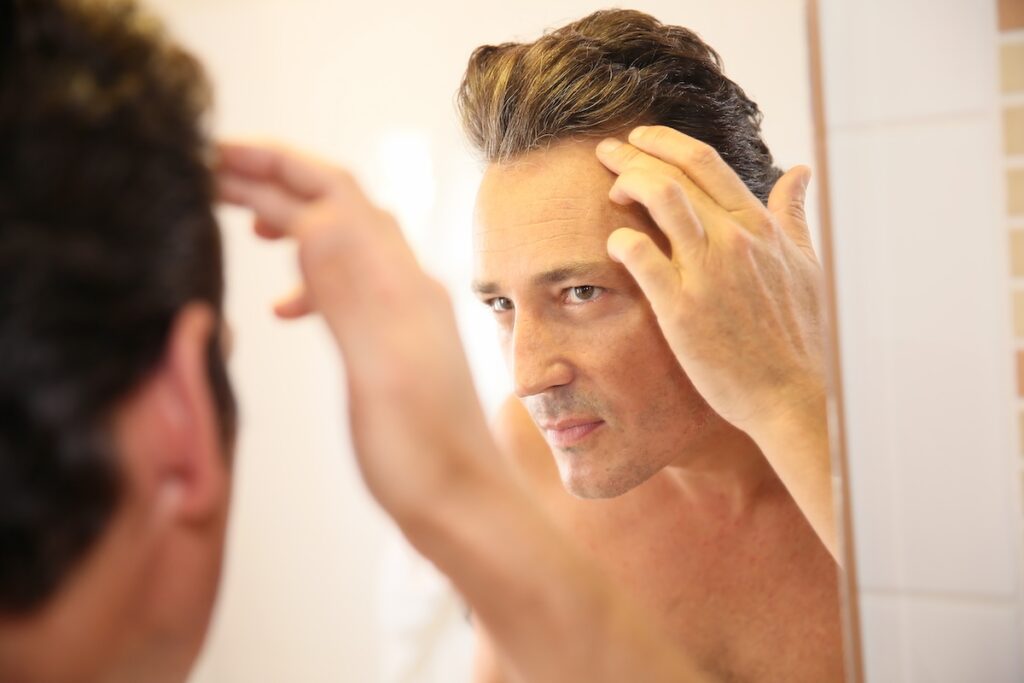 Man examining hair loss