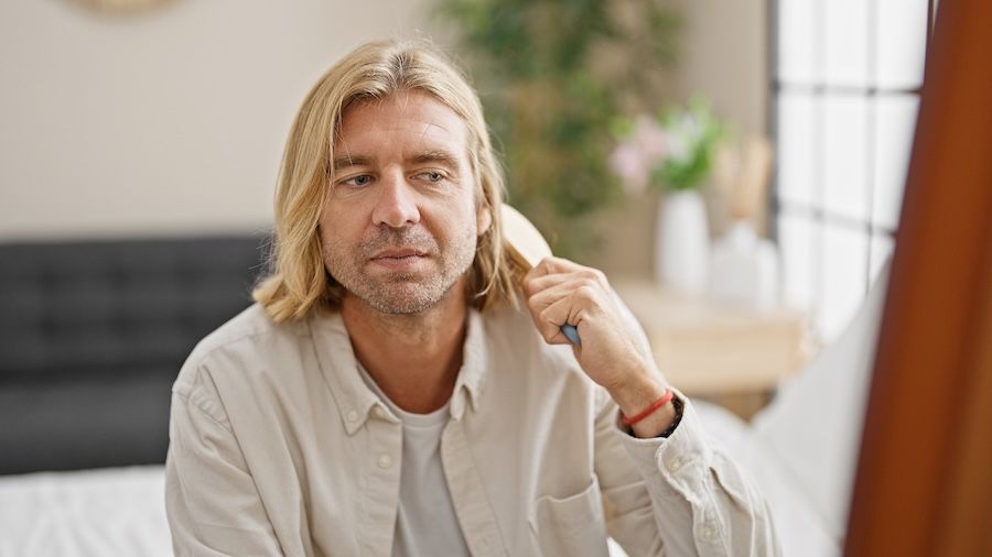 man brushing mid length hair