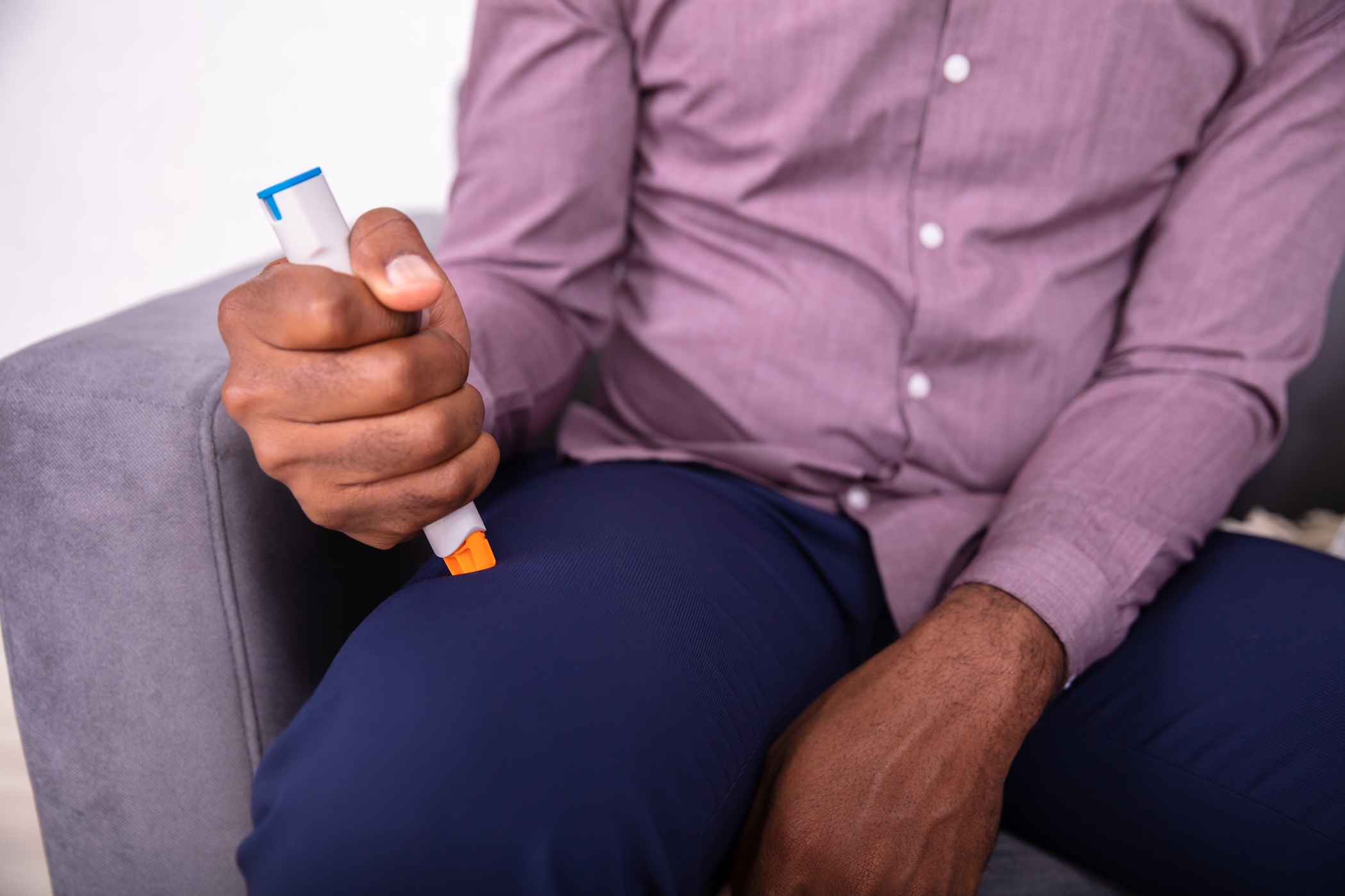 Man administering epinephrine for anaphylaxis